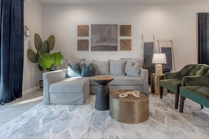 A modern living room with a sofa, coffee table, and decorative items.