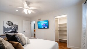 A bedroom with a bed, a ceiling fan, a TV, and a walk-in closet. - 306 Jason Court, Woodstock (Woodstock)