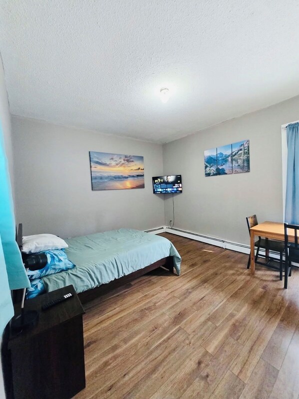 A small, clean room with a bed, a desk, and a TV. - Nice apartment near Whole Foods, Brown University, Miriam, RI Hospital, Downtown (Providence)