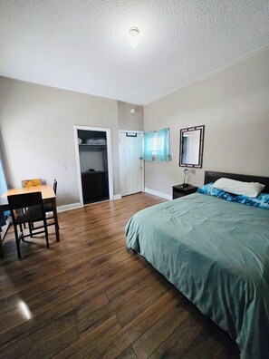 A bedroom with a bed, a desk with a chair, a wardrobe, and a mirror on the wall. - Nice apartment near Whole Foods, Brown University, Miriam, RI Hospital, Downtown (Providence)