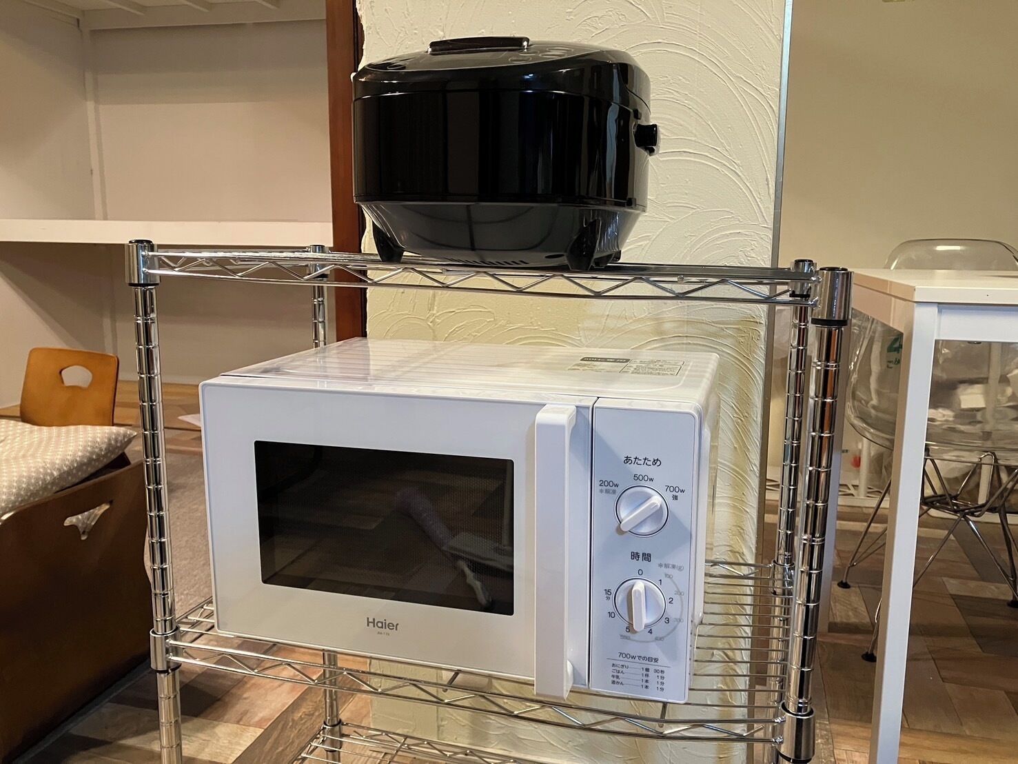 A Haier microwave oven on a metal shelf.