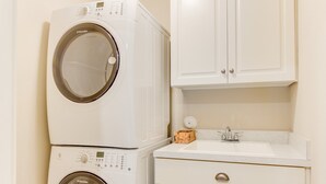 A compact laundry room with two stacked washing machines, a sink, and white cabinetry. - 404b The Princess Anne House South End Spacious 4 Beds Townhouse (Virginia Beach)