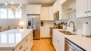 Een moderne keuken met witte kasten, roestvrijstalen apparatuur en een centraal eiland.