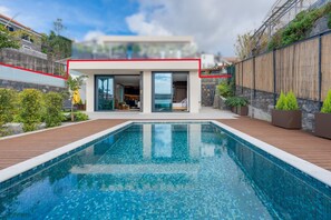 A modern house with a swimming pool, a patio, and a view of the neighborhood. - BHF Residences Luxe Family   (Arco da Calheta)