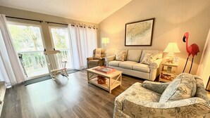 A living room with a sofa, a chair, a coffee table, and a lamp. - 601 Double Eagle Trace (Seabrook Island)