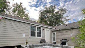 A hot tub in a backyard with a house in the background. - 5BR 3BA Home With Hot Tub Near Stadiums & Airport (Houston)