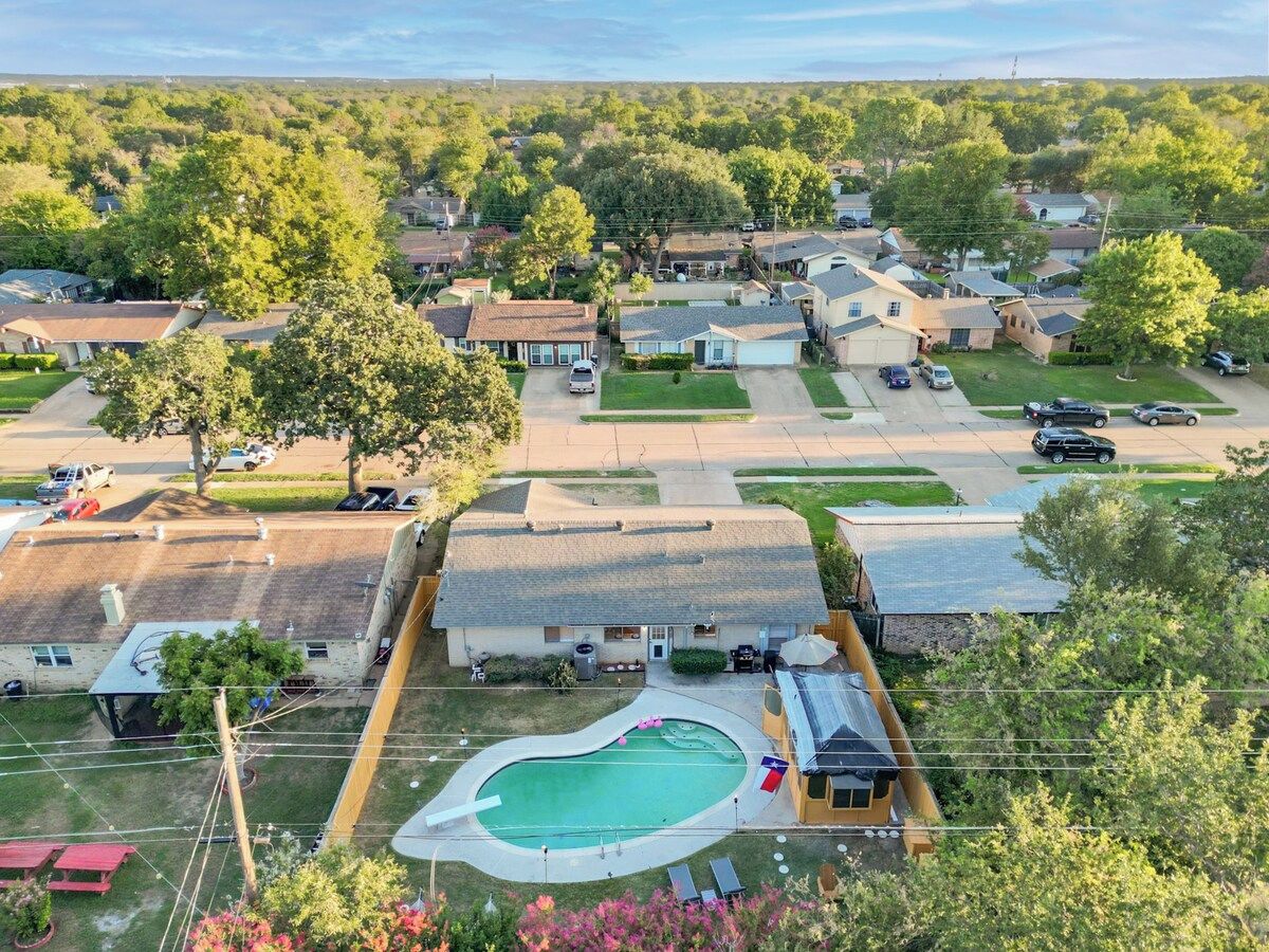 A residential area with houses, a swimming pool, and a clear sky.