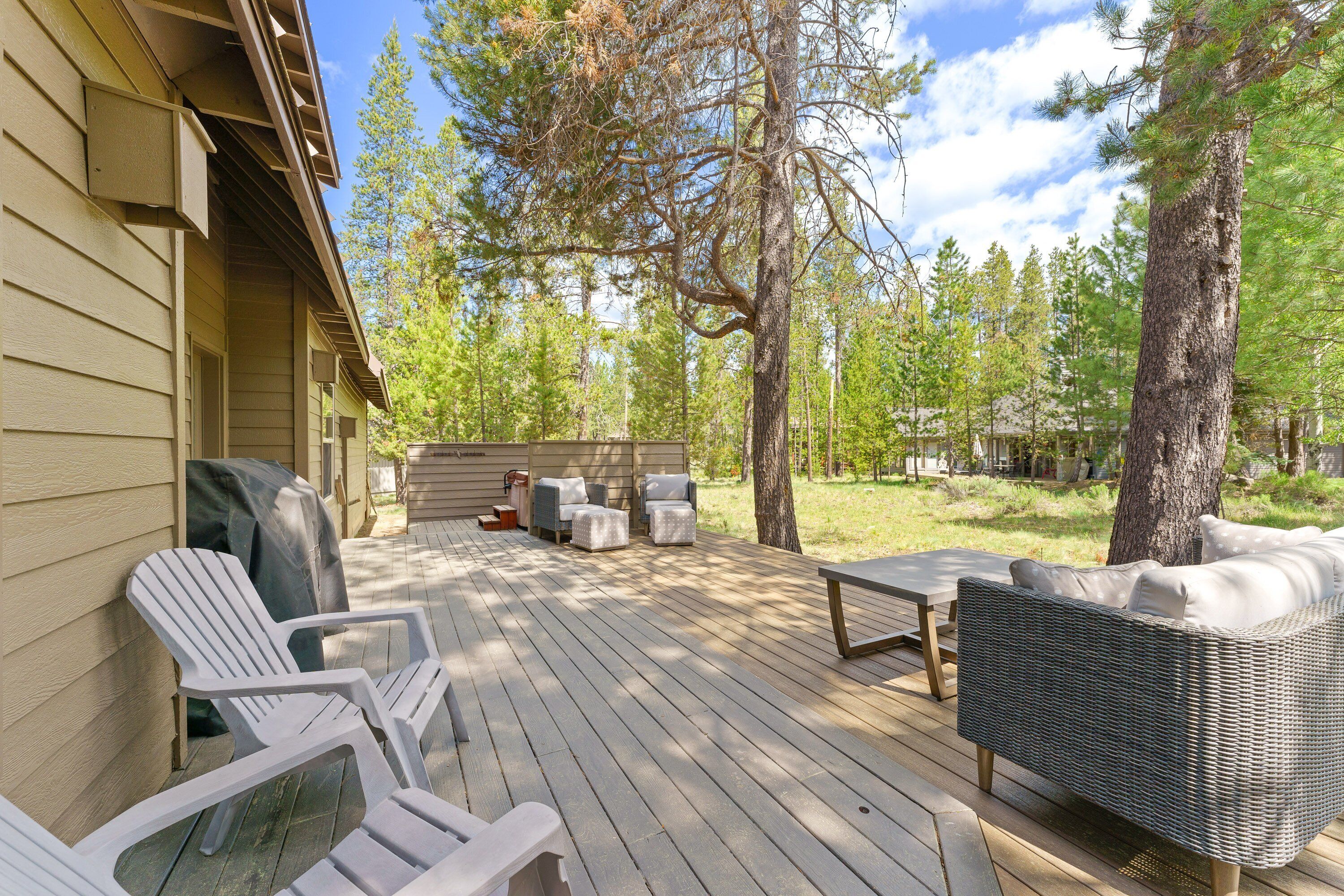 A deck with outdoor furniture, including chairs and a sofa, and a grill.