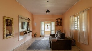 Un salon comprenant un canapé, un téléviseur, une table basse et un tapis à motifs.