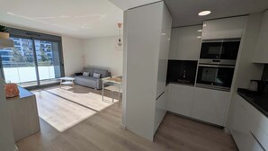 Un appartement moderne comprenant une cuisine, un coin repas et un salon.