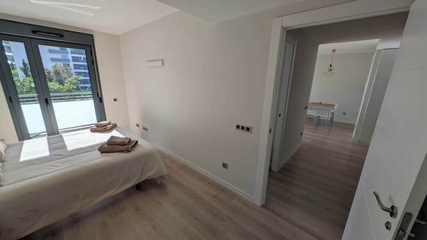 Une chambre à coucher avec un lit, une fenêtre et une vue sur les bâtiments environnants.