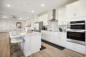 A modern kitchen with white cabinetry, stainless steel appliances, and a central island. - 95070 Gina Street (Fremont)