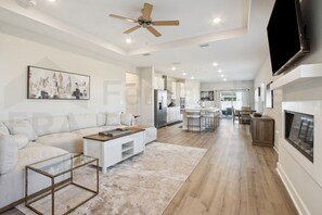 A modern living room with a sofa, coffee table, and a ceiling fan. - 95070 Gina Street (Fremont)