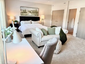 A modern bedroom with a bed, bedside tables, a desk, and a chair. - New! Beautifully appointed 3-bedroom townhome 30 min from Purdue - Remington IN (Remington)