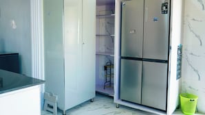 A compact kitchen with a built-in refrigerator, a small sink, and a countertop.