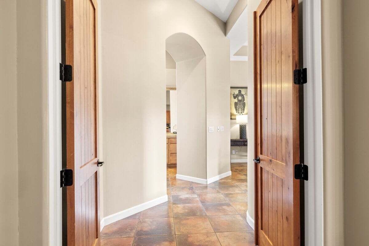 A hallway with wooden doors and a tiled floor.