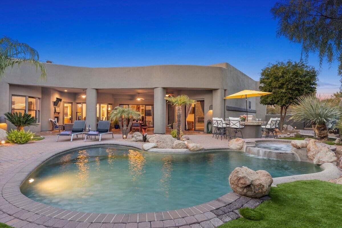 Uma casa moderna com piscina, área de estar externa e um pátio.