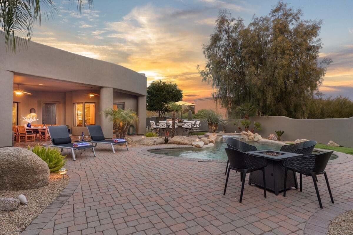 Eine Terrasse mit Pool, Liegestühlen und Essbereich.