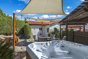 A hot tub in a backyard with a pergola, outdoor furniture, and a house in the background. - Cardillo 3 (Palm Springs)