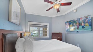 A bedroom with a bed, a ceiling fan, a window, a dresser, and a wall-mounted TV. - Di0103 Centre Court Amore (Kissimmee)