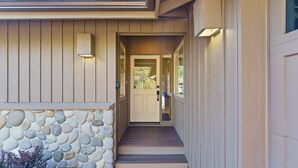 Una casa con fondamenta in pietra, una porta d'ingresso in legno e una scalinata che conduce all'ingresso.