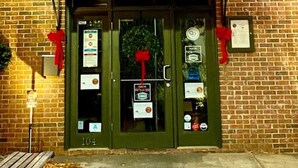 A brick building with a sign reading "The Strip Club 104 A Steak House" above the entrance. - Historic Home in Downtown Greer Shop,eat & Sleep (Greer)
