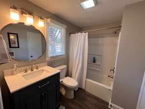 A bathroom with a sink, toilet, and bathtub. - Historic Home in Downtown Greer Shop,eat & Sleep (Greer)