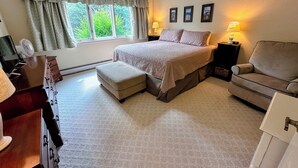 A bedroom with a bed, a chair, a desk, a lamp, and a window with curtains. - Fv43 Bretton Woods Single Level Home With AC on Golf Course! (Rye)