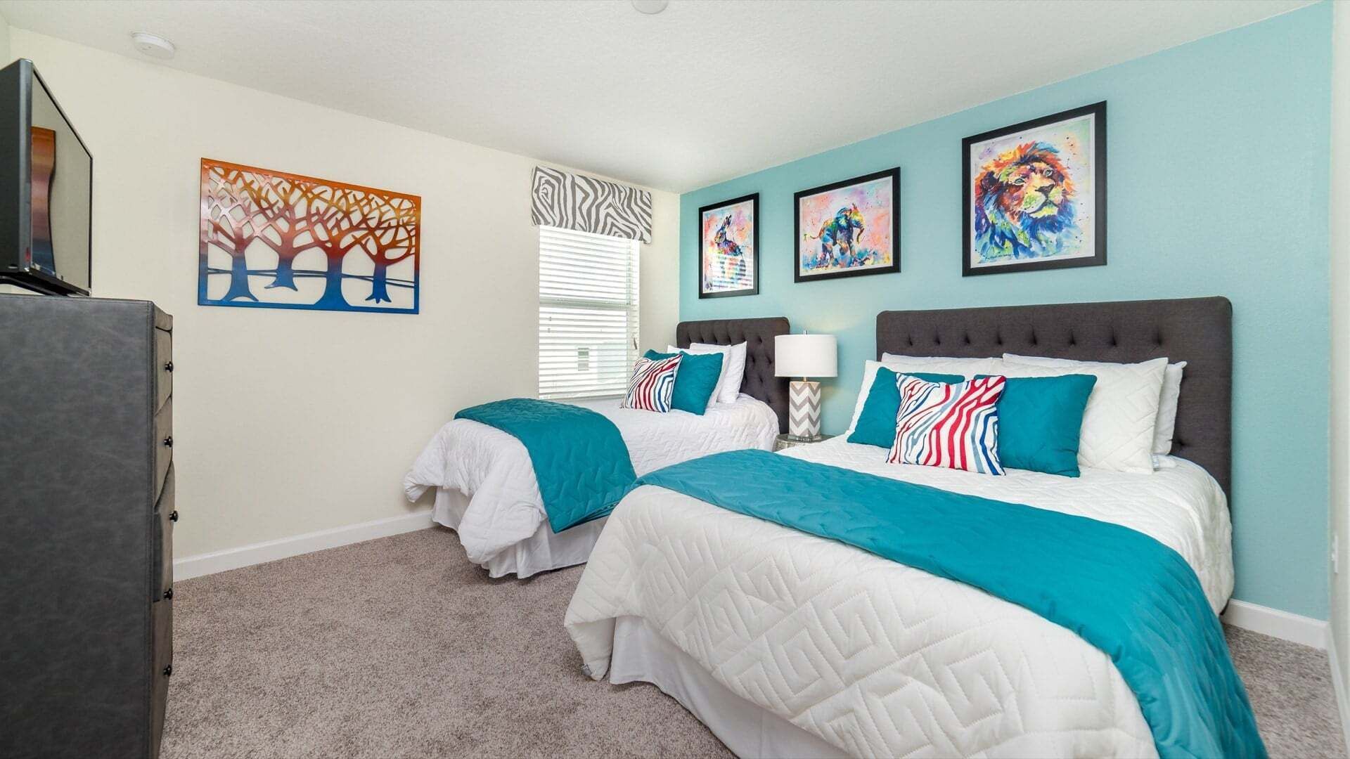 Een slaapkamer met twee bedden, een dressoir en kunstwerken aan de wand.