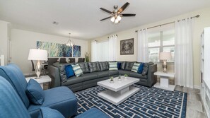 A modern living room with a sectional sofa, a coffee table, and a ceiling fan. - Hzd9088 (Davenport)
