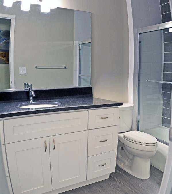 A modern bathroom with a white vanity, a sink, a mirror, and a toilet. - Holiday House 3 (Siesta Key)