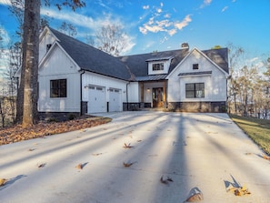 A large, single-story house with a garage, a covered entryway, and a driveway. - Lakeside Haven With Gourmet Kitchen (Hartwell)