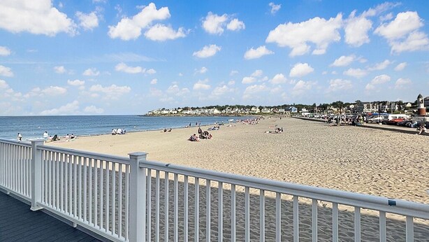 A beach with a white wooden deck and a white railing. - Kurtz Cottage - Y856 (York Beach)