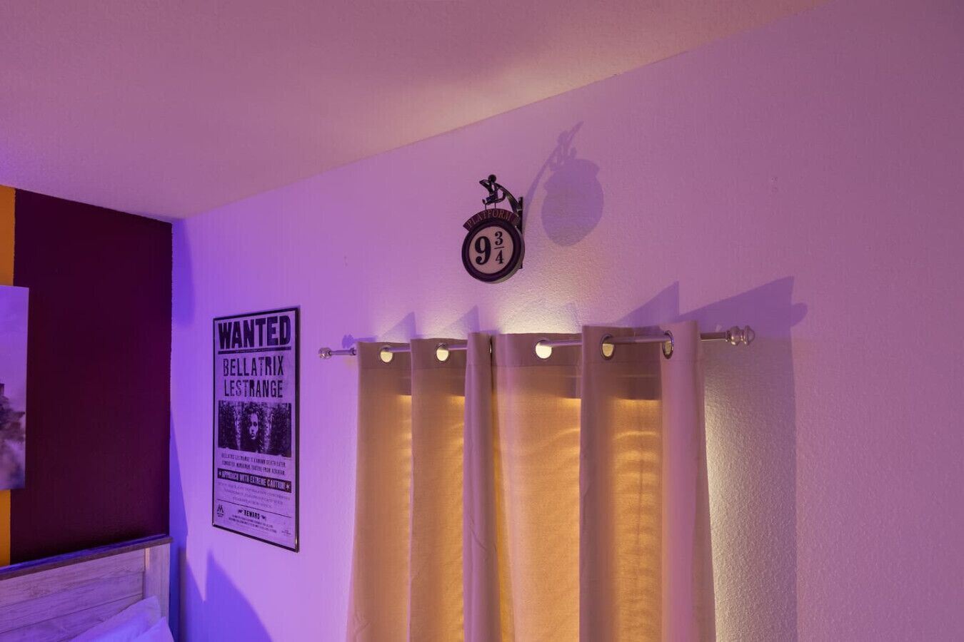 Ein Badezimmer mit Duschvorhang, einer Wanduhr und einem 'WANTED'-Poster.