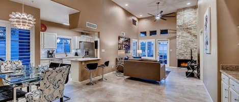 A spacious living area with a kitchen, dining table, and seating.