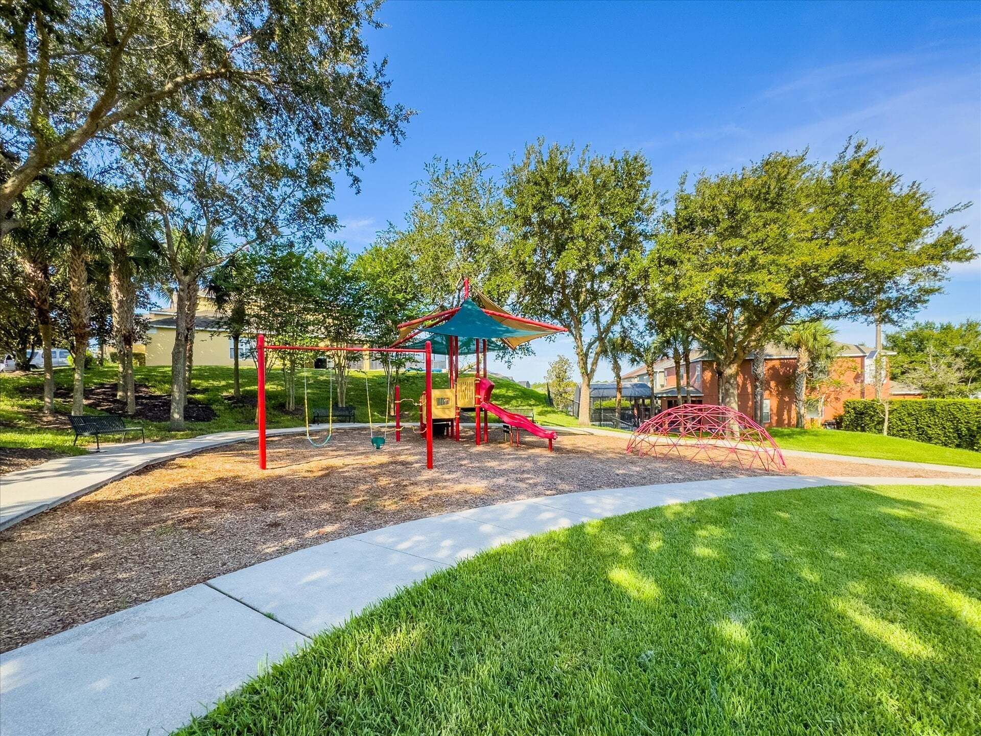 A playground with swings, a slide, and a climbing structure.