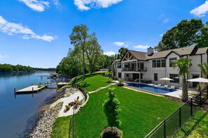 A lakeside property with a swimming pool, dock, and well-maintained lawn. - Hogan Crest (Mooresville)