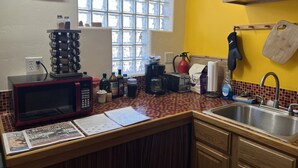 Une cuisine équipée d’un four à micro-ondes, d’un grille-pain, d’une machine à café et d’une fenêtre donnant sur un beau paysage.