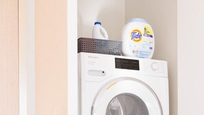 A stacked washer and dryer unit with Tide detergent on top. - Exclusive Midtown Luxury Step From Times Square! (New York)