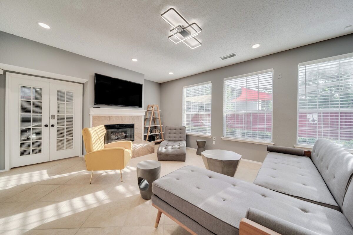A modern living room with a grey sofa, a yellow armchair, and a fireplace.