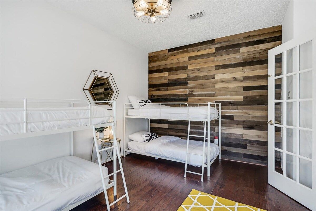 A bunk bed room with a wooden wall and a white door.