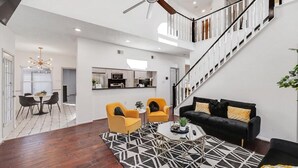 A spacious living area with a staircase, a dining area, and a kitchen. - Glamorous 4BR 2B Home With Pool, Game Room & Fire Pit (Mesquite)