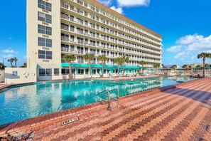A hotel with a large pool area, multiple balconies, and a clear blue sky. - Harbour Beach Resort 518 (Daytona Beach)