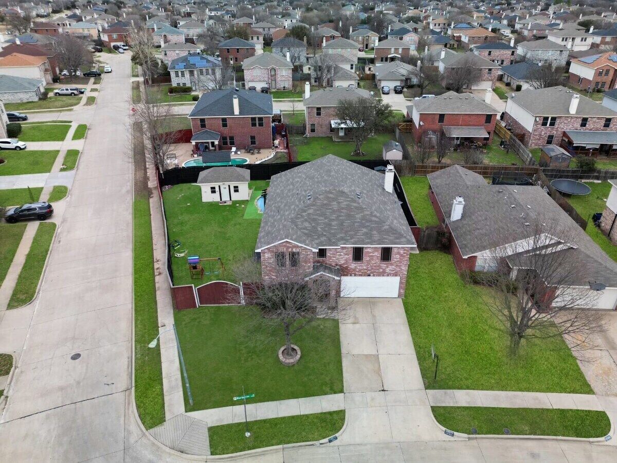 A suburban neighborhood with houses, a driveway, and a front yard.