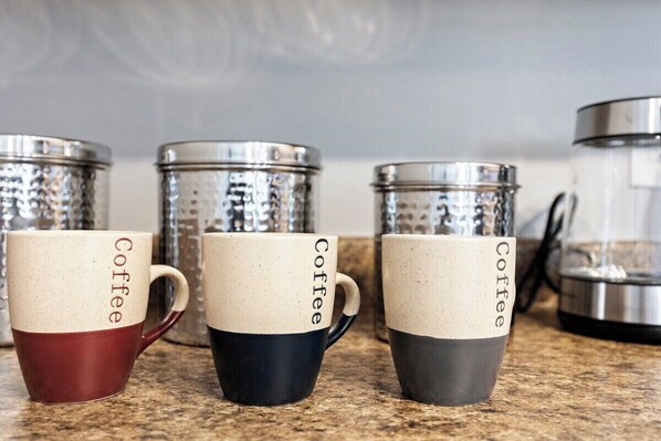 Three coffee mugs with the word "Coffee" on them, placed on a countertop. - Minnezona (Scottsdale)