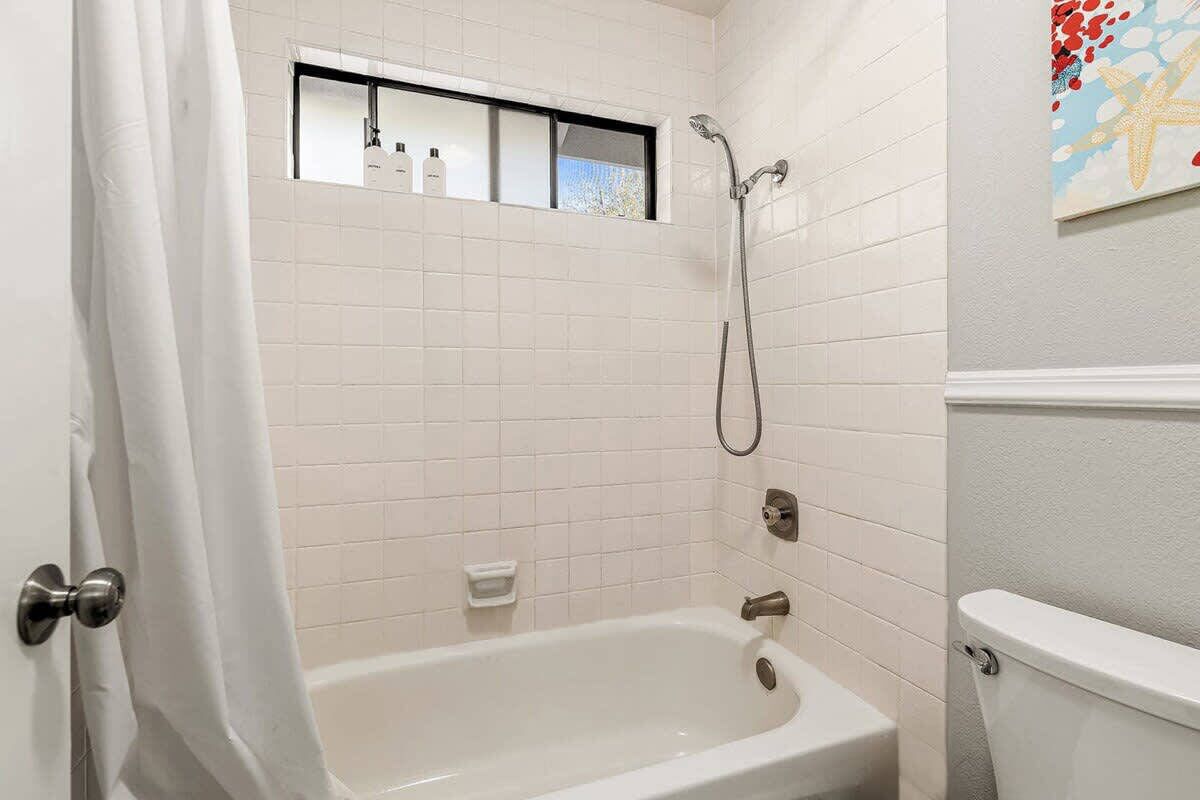 A bathroom with a bathtub, a shower, and a toilet.