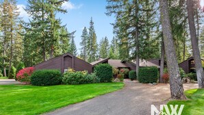 A row of cabins with a gravel driveway leading to a wooden gate. - Twin Lakes Village Home Golf Retreat Community Pool Corner Lot and Single Level Living (Rathdrum)