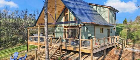Eine Holzhütte mit einer Holzterrasse, einer Veranda und einem Metalldach.