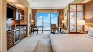 Ein Hotelzimmer mit Küche, Essbereich, Bett und einem großen Fenster mit Aussicht.