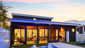 Een modern huis met een zwembad, een terras en grote ramen.